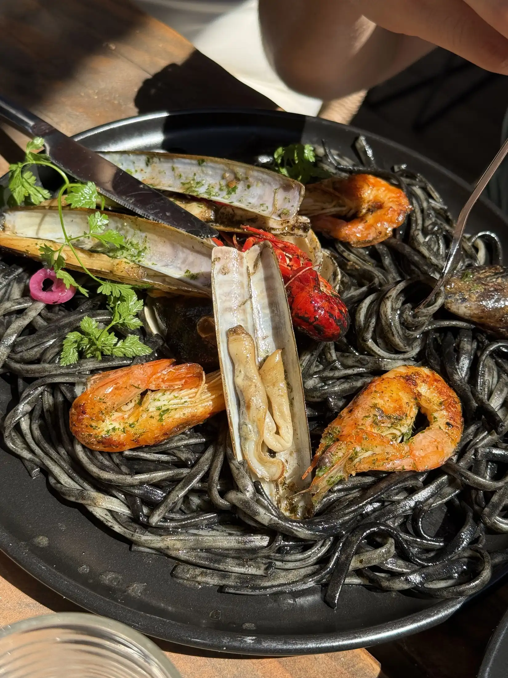 Linguines à l'encre de seiche garnies de crevettes et de coquillages
